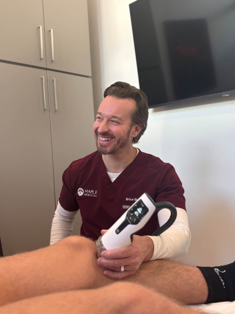 Maple Medical provider using focused shockwave therapy on a patient’s knee