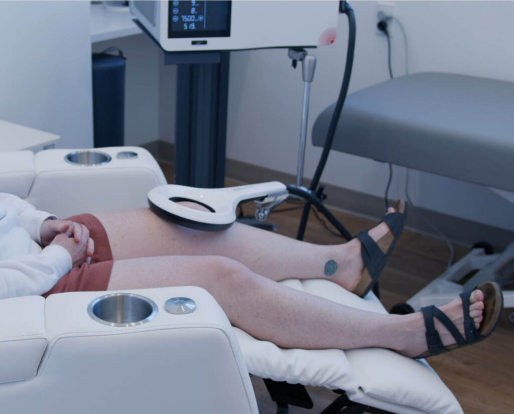 Patient receiving EMTT therapy for lower body pain at Maple Medical
